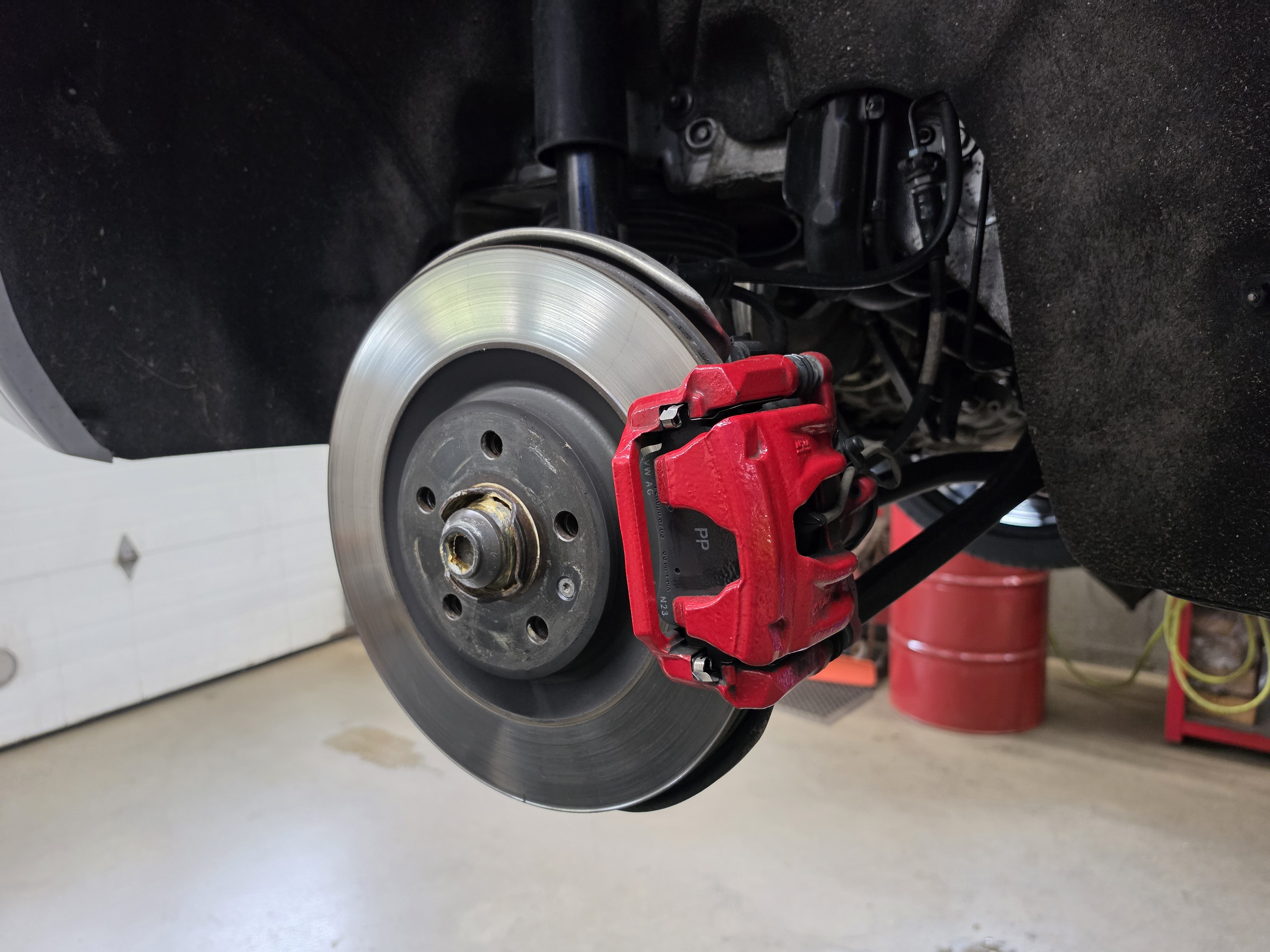 Fresh rotor and red brake caliper at Akin Automotive